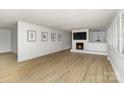 Spacious living room boasting a fireplace with a wall-mounted TV, neutral walls, and wood-look flooring at 7407 Forney Hill Rd, Denver, NC 28037