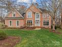 Beautiful brick residence showcasing a manicured lawn, lovely landscaping, and a grand entrance at 9904 Duane Ct, Huntersville, NC 28078