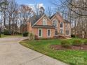 Spacious brick home with a long driveway, complemented by lush greenery and mature trees at 9904 Duane Ct, Huntersville, NC 28078