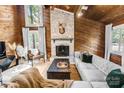 Bright living room with wood paneled walls, fireplace, and comfortable seating area at 11101 Winding Way Rd, Charlotte, NC 28226