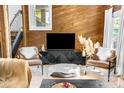 Cozy living room with wood paneled walls, stylish furniture, and natural light at 11101 Winding Way Rd, Charlotte, NC 28226