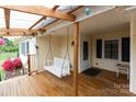 Inviting front porch with a wooden swing, string lights, and covered roof at 115 Setter Ct, Statesville, NC 28625