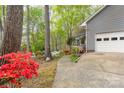 A charming home exterior with colorful azaleas lining a long driveway leading to an attached garage at 140 Rustic Way Ln, Mooresville, NC 28117