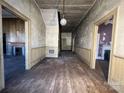 Spacious hallway with wood floors and visible doorways to other rooms in need of repair at 148 Center St, Chester, SC 29706