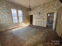 Empty room with hardwood floors, fireplace and original wallpaper at 148 Center St, Chester, SC 29706