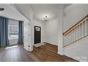 Bright foyer featuring hardwood floors, a staircase, and elegant lighting fixture at 15603 Pine Glen Ct, Charlotte, NC 28273