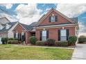 Well-maintained brick home with black shutters, complemented by a green lawn and walkway at 2555 Holly Oak Ln, Gastonia, NC 28056