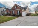 Attractive brick home with a two-car garage and spacious driveway, surrounded by greenery at 2555 Holly Oak Ln, Gastonia, NC 28056