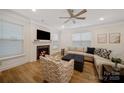 Inviting living room with a fireplace, ceiling fan, plush seating, and ample natural light at 3899 Center Place Dr, Harrisburg, NC 28075