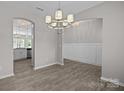 Open dining room area with modern chandelier and wood floors, seamlessly connecting to the kitchen and living spaces at 531 Harlech Ct, Fort Mill, SC 29715