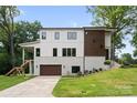 Modern two-story home with a brick and white facade, a brown garage door, and a well-manicured lawn at 5610 Farmbrook Dr, Charlotte, NC 28210
