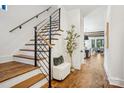 Inviting hallway with hardwood floors, staircase with metal railings, and stylish decor at 5610 Farmbrook Dr, Charlotte, NC 28210