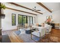 Bright living room featuring exposed beams, modern furniture, and a view of the outdoor landscape at 5610 Farmbrook Dr, Charlotte, NC 28210