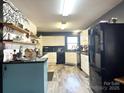 Well-lit kitchen features white cabinets, black appliances, and stylish decor at 583 Old Wilkesboro Rd, Taylorsville, NC 28681