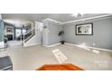 Spacious living room featuring plush carpeting, crown molding, and an open staircase at 6523 Matlea Ct, Charlotte, NC 28215
