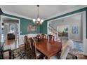 Inviting dining room with rich green walls, wood trim, and a view of the staircase and living spaces at 705 Drew Ave, Fort Mill, SC 29708
