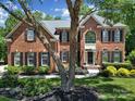 Charming brick home featuring a well-manicured lawn and classic architectural details, framed by a mature tree at 705 Drew Ave, Fort Mill, SC 29708