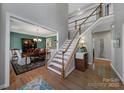 Elegant foyer with hardwood floors, a staircase with white railings, and a view of the formal dining room at 705 Drew Ave, Fort Mill, SC 29708