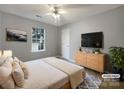 Cozy bedroom with a ceiling fan, window, and minimalist decor, offering a comfortable and inviting space at 7926 Sir Barton Ct, Charlotte, NC 28215