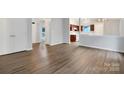 Spacious living area showcasing wood-look flooring and an open layout, with a view into the adjacent kitchen space at 7926 Sir Barton Ct, Charlotte, NC 28215