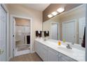 Bathroom featuring double sinks with white cabinets, a large mirror, and a walk-in shower at 8568 Windsor Ridge Dr, Charlotte, NC 28277