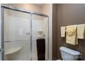 Close up view of shower with glass doors, tile, seating and multiple shelves for storage at 8568 Windsor Ridge Dr, Charlotte, NC 28277