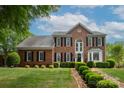 Charming two-story brick home with manicured lawn and landscaping, showcasing classic architectural details at 1006 Baldwin Ln, Waxhaw, NC 28173