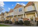 Attractive townhome featuring a covered entrance, stone pillars, and tidy landscaping at 11013 Dundarrach Ln, Charlotte, NC 28277