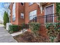 Charming brick townhouse featuring a private entrance with black iron railings and lush green landscaping at 121 Irving Ave # F, Mooresville, NC 28117