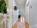 Inviting hallway featuring hardwood floors, neutral paint, and natural light from the french doors at the end at 121 Irving Ave # F, Mooresville, NC 28117