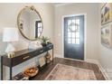 Elegant foyer features a decorative mirror above a console table, stylish lighting, and a patterned area rug at 15103 Honeycutt Dr, Huntersville, NC 28078