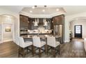 Open kitchen boasts dark cabinetry, granite countertops, stainless steel appliances, and a breakfast bar with seating at 15103 Honeycutt Dr, Huntersville, NC 28078