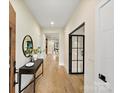 Elegant entryway featuring hardwood floors, neutral walls, stylish console table, and modern black-framed glass door at 1516 N Caldwell St, Charlotte, NC 28206