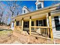 Detailed view of the covered front porch with brick base and wood railings at 177 Highland Woods Ct, Denver, NC 28037
