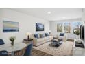 Bright, staged living room featuring neutral furniture, blue accents, and plenty of natural light from the large windows at 225 Kennerly Ave # A, Mooresville, NC 28115
