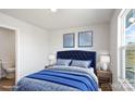 Comfortable main bedroom with plush blue bedding, bedside lamps, and natural light from the window at 225 Kennerly Ave # A, Mooresville, NC 28115