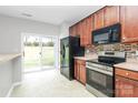 Bright kitchen features stainless steel appliances, wooden cabinets, and sliding glass doors to the backyard at 2313 Calabassas Ln, Matthews, NC 28105