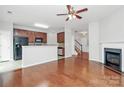 Open-concept living room with hardwood floors, fireplace, and kitchen with stainless steel appliances at 2313 Calabassas Ln, Matthews, NC 28105
