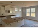 Unfinished kitchen featuring white cabinets, a large island, and natural light from the windows at 237 Miramar Dr, York, SC 29745
