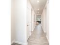 Bright hallway featuring light wood floors, white trim, and neutral paint at 2405 Lorelei Ter, Monroe, NC 28112