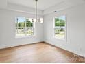 Bedroom with hardwood floors, recessed lighting, and tray ceiling with pendant lighting, creating a serene atmosphere at 2425 Ellen Ave, Charlotte, NC 28208