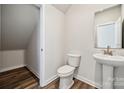 Well-lit half bathroom featuring a pedestal sink, toilet, and storage access at 310 Bezelle Ave, York, SC 29745