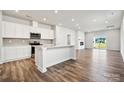 Open-concept kitchen featuring white cabinetry, stainless steel appliances, and hardwood flooring at 310 Bezelle Ave, York, SC 29745