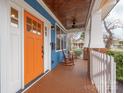 Inviting front porch features a wood ceiling, orange door, rocking chairs and white railing at 331 Solomon St, Charlotte, NC 28216