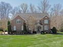 Charming brick two-story home with symmetrical facade and manicured front lawn at 409 Running Horse Ln, Waxhaw, NC 28173