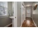 Stylish powder room with a pedestal sink, wood floors and bright natural light at 7834 Jester Park Dr, Huntersville, NC 28078