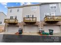Rear view of townhomes with individual balconies above garage doors at 824 Imperial Ct, Charlotte, NC 28273