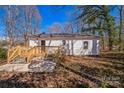 View of the home's back exterior, showcasing a wooden deck and spacious yard with mature trees at 1229 Jenkins St, Rock Hill, SC 29732