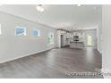 Open living space showcasing hardwood floors and leading to a modern kitchen with a central island at 156 Tangle River Dr # 35, Statesville, NC 28677