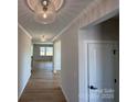 Bright hallway featuring stylish light fixtures, wood floors, and views into the home's living spaces at 2211 Camber Dr # Cwo0103, Gastonia, NC 28054